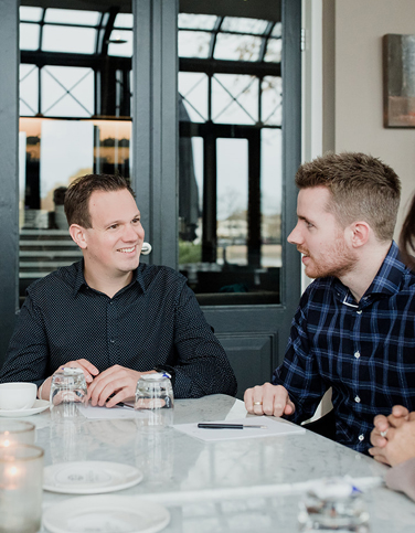 Twee mannen geanimeerd met elkaar in gesprek aan tafel