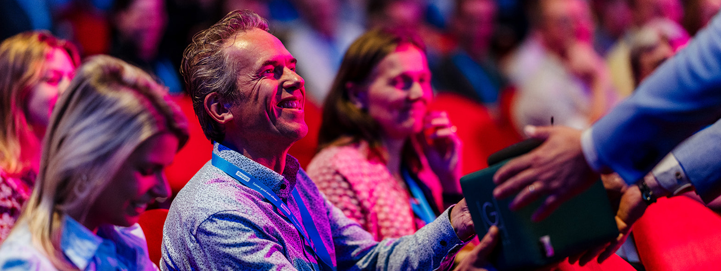 publiek in theaterzaal bij Dimpact-congres 2025