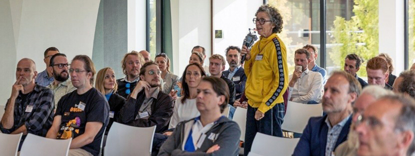publiek met vrouw in het midden staand met microfoon