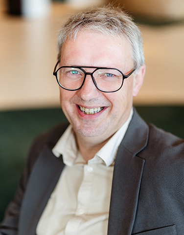 Man met bril kijkt in camera